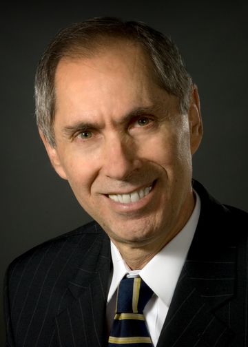 Adiel Fleischer, MD, wearing a striped suit and blue and gold tie